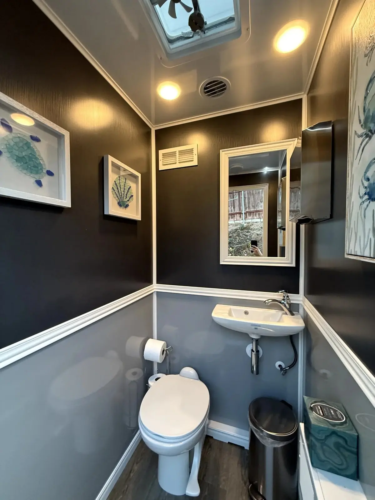 Clean portable restroom interior with a flushing toilet and handwashing sink for a Hillcrest event.