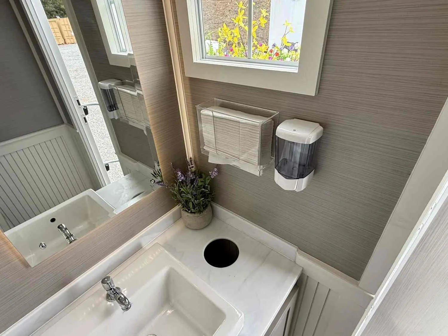 Self-contained restroom trailer positioned outside a property during a bathroom renovation.